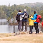 Multi-generational family of hikers overlooking a lake